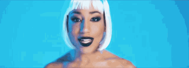 a woman wearing a white wig and black lipstick is smiling