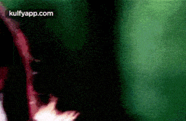 a close up of a person 's face with a green background