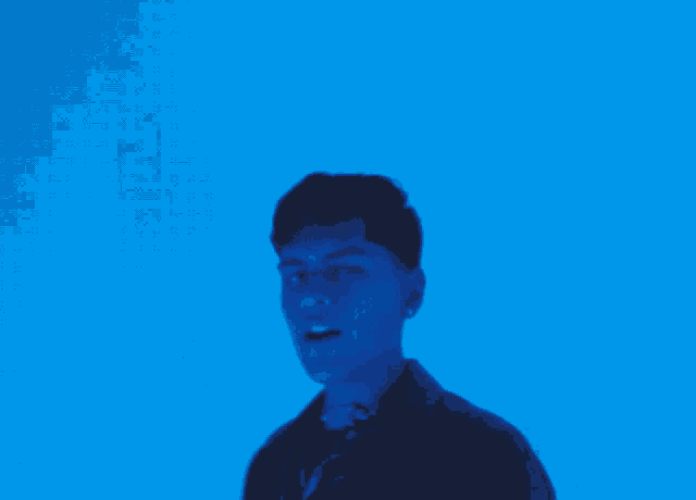 a man and woman are standing in front of a blue background