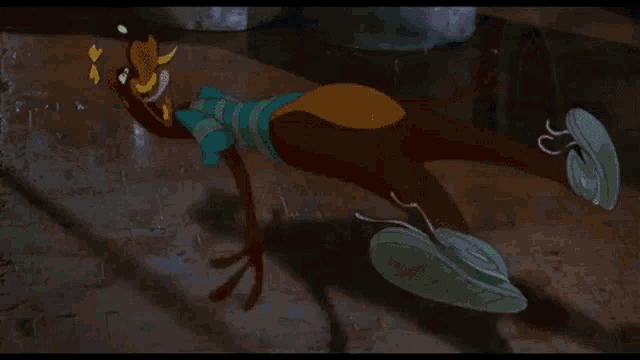 a green cartoon character is sleeping on a rocking chair .