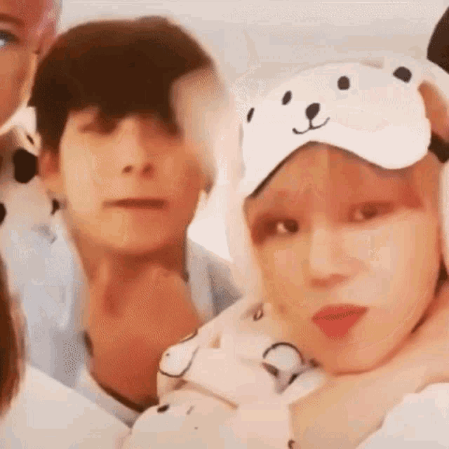 a group of people are standing next to each other and one of them is wearing a teddy bear mask .