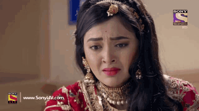 a woman is crying in front of a sony tv ad