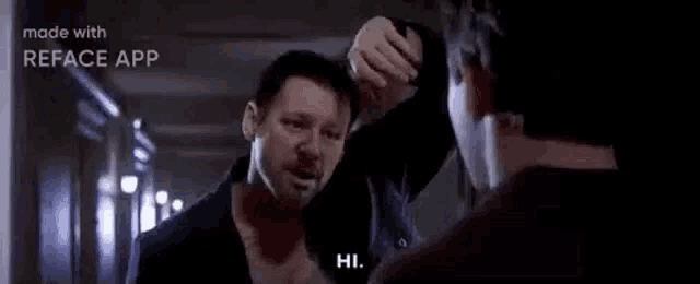 two men are standing next to each other in a hallway .