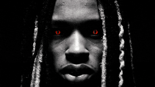 a black and white photo of a person with red eyes