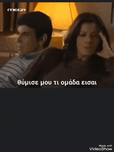 a man and a woman are sitting next to each other on a couch in a room with a lamp .