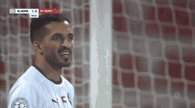 a soccer player stands in front of a goal during a game