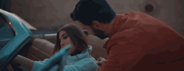 a man kisses a woman in a car