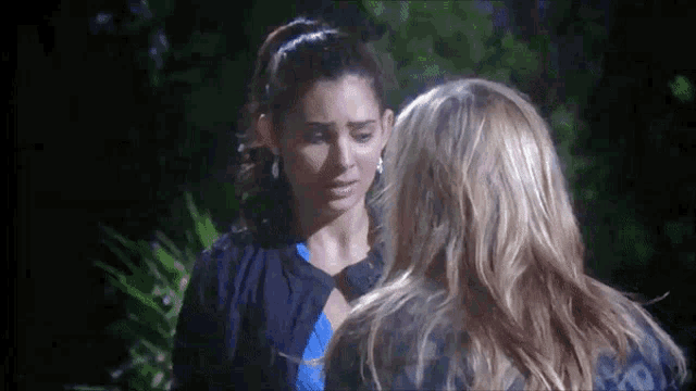 two women are standing next to each other and one is looking down