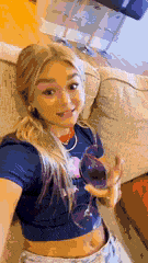 a woman is sitting on a couch holding a wine glass .