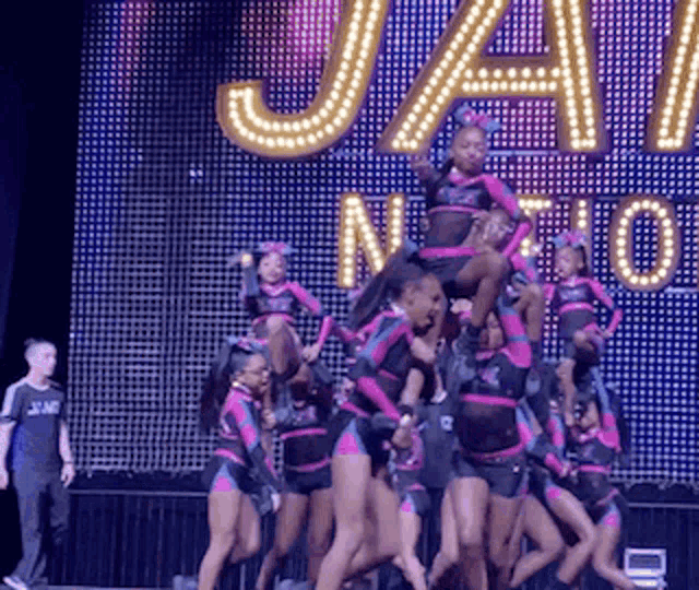 a group of cheerleaders are performing in front of a sign that says ' jay nation '