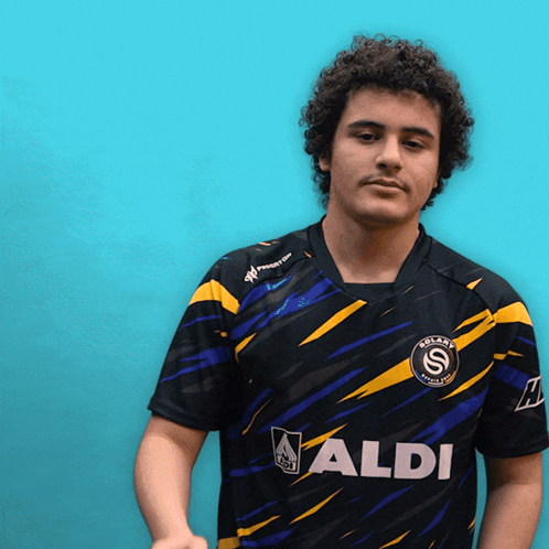 a man wearing a black and yellow shirt that says aldi on it