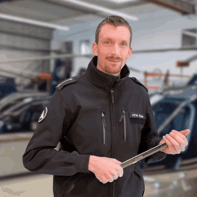 a man wearing a jacket that says hta one on it