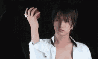 a shirtless man is holding an apple in his hand .