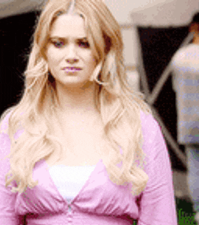 a woman wearing a pink cardigan and a white shirt