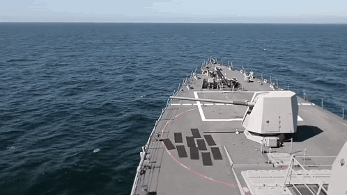a large ship with a large cannon on the deck is in the ocean
