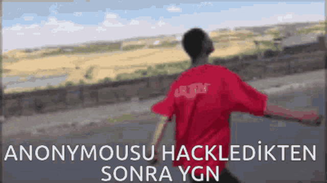 a man in a red shirt with the word anonymous on the back is running