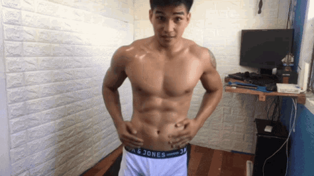 a shirtless man is standing in a room wearing a pair of underwear that says jack & jones on the waistband