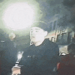 a man is standing in front of a crowd holding a flashlight .