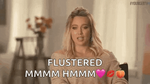 a woman is sitting in a chair and saying flustered mmmm hmmm .