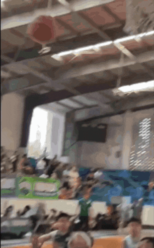 a group of people are sitting in a gym watching a game .