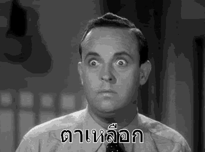 a man in a suit and tie is making a funny face and looking at the camera .