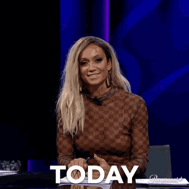 a woman sits at a table with the word today written on it