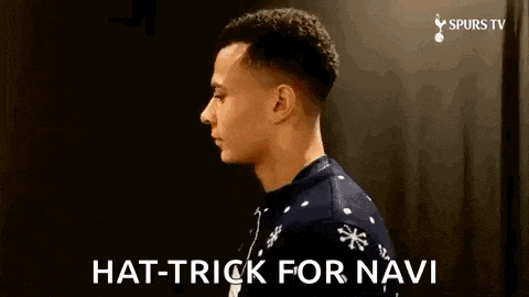 a man wearing a christmas sweater is standing in front of a black wall and says `` hat trick for navi '' .