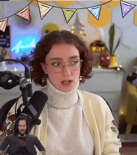 a woman wearing glasses is sitting in front of a microphone in front of a sign that says " fuck "