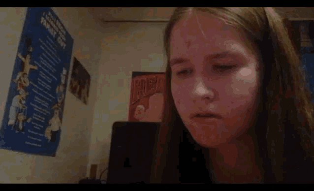 a girl in a room with a poster on the wall that says ' a few lines ' on it