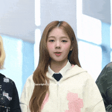 a girl wearing a white hoodie with a pink cat on the front