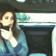 a woman is taking a picture of herself in the back seat of a car
