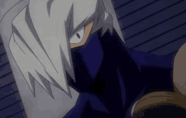 a close up of a person wearing a mask and a blue shirt .