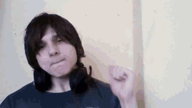 a young man wearing headphones is making a funny face .