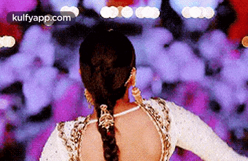 the back of a woman wearing a braided ponytail is shown .