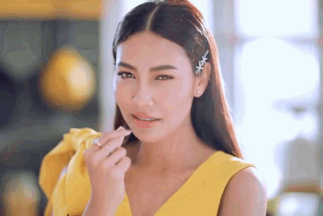 a woman in a yellow dress is eating something