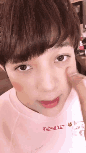 a close up of a person 's face with a pink shirt that says @bbasrtr