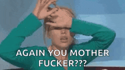 a woman in a green sweater is covering her face with her hands .