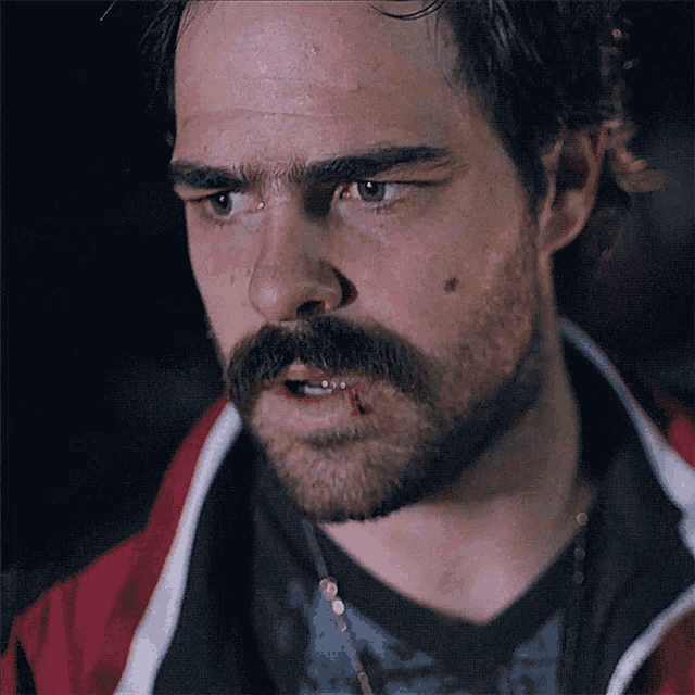 a man with a mustache has a bloody mouth