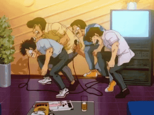 a group of men singing into microphones in front of a tv