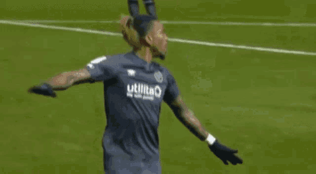two soccer players are hugging each other on the field .