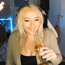a woman wearing headphones is drinking from a bottle while playing a video game .