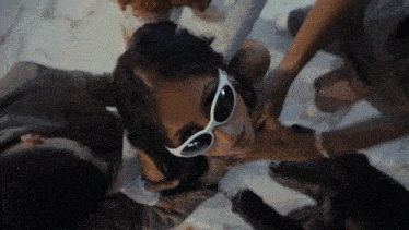 a woman wearing white sunglasses is surrounded by other people