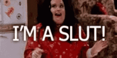 a woman in a red dress is standing in front of a refrigerator and saying `` i 'm a slut '' .