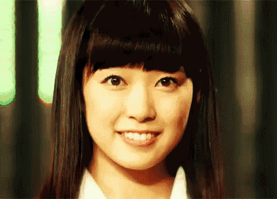 a close up of a woman 's face with a smile
