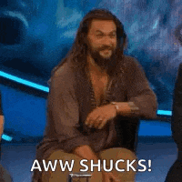 a man with a beard is sitting in a chair and making a face .