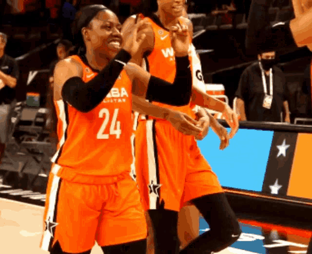 a basketball player wearing a number 24 jersey applauds her teammates