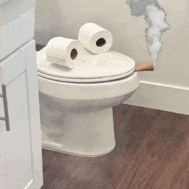 a toilet with two rolls of toilet paper on it and smoke coming out of it