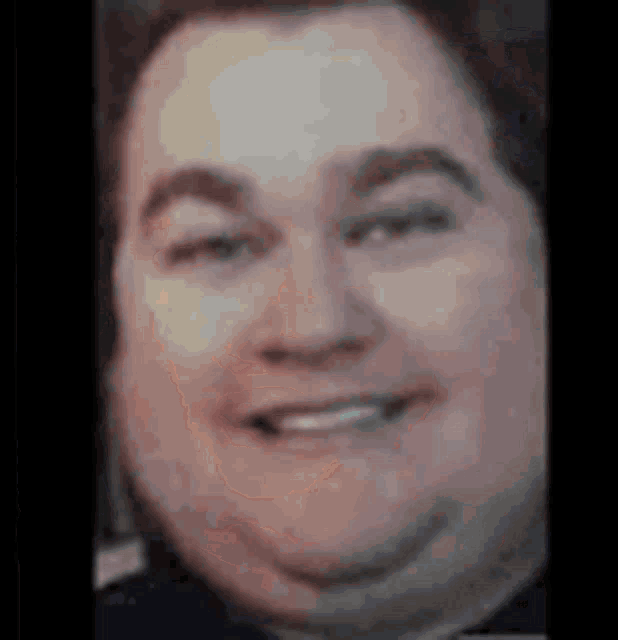 a close up of a man 's face with a big smile on his face .