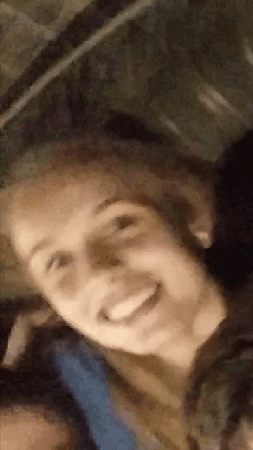 a close up of a person 's face smiling and looking at the camera