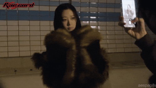 a woman in a fur coat is being photographed by a person with the word ranger on the bottom right